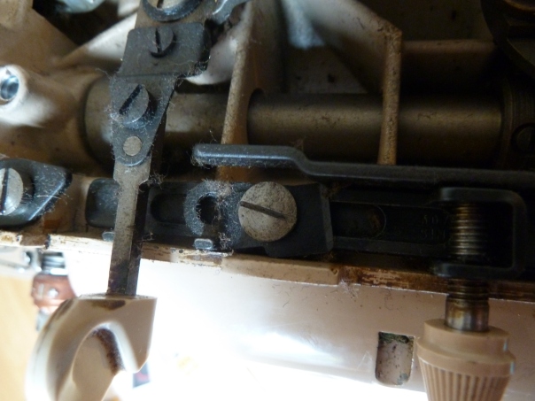Close-up of the mechanism. Stitch-width selector to the left, one of the mystery levers to the right.